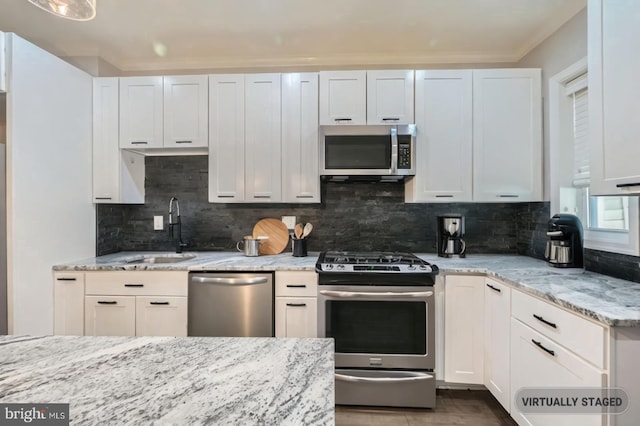 3540 Keswick Rd, Baltimore, MD 21211 - kitchen featuring appliances with stainless steel finishes, a sink, light stone countertops, decorative backsplash, and wood finished floors