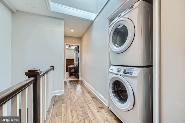 3540 Keswick Rd, Baltimore, MD 21211 - laundry area featuring stacked washer and clothes dryer, light wood finished floors, baseboards, and recessed lighting