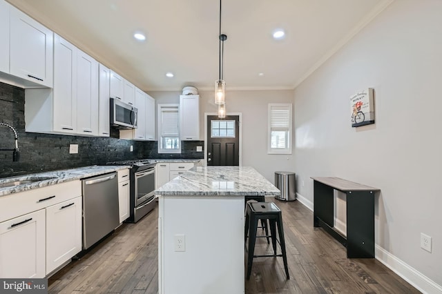 3540 Keswick Rd, Baltimore, MD 21211 - kitchen featuring stainless steel appliances, ornamental molding, a sink, decorative backsplash, and a breakfast bar area