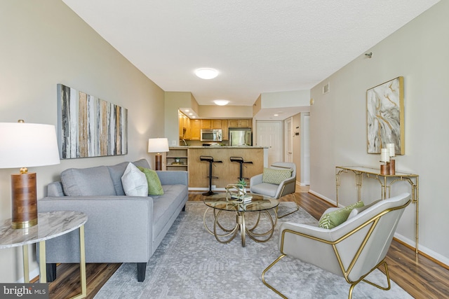 1001 N Randolph St Unit 513, Arlington, VA 22201 - living room featuring wood finished floors, baseboards, and a textured ceiling