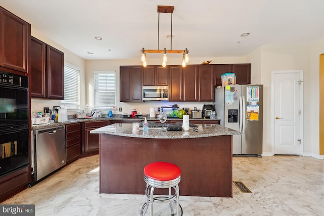 7306 Sudley Ave, Brandywine, MD 20613 - kitchen featuring stainless steel appliances, light stone counters, a kitchen island with sink, decorative light fixtures, and light marble finish flooring