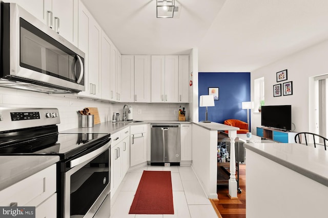 2630 Adams Mill Rd NW Unit 306, Washington, DC 20009 - kitchen with stainless steel appliances, backsplash, white cabinets, light countertops, and light tile patterned floors