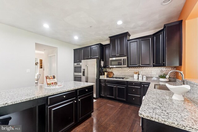 14302 Hidden Forest Dr, Accokeek, MD 20607 - kitchen featuring a sink, appliances with stainless steel finishes, dark wood finished floors, dark cabinets, and decorative backsplash