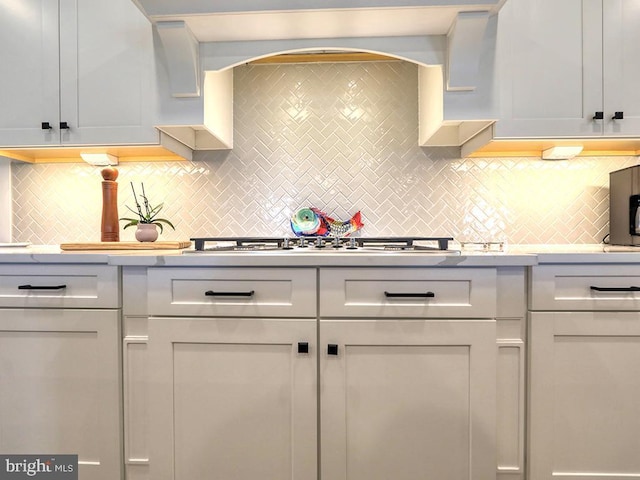 33016 Ethan Allen Dr, Rehoboth Beach, DE 19971 - kitchen with light countertops, stainless steel gas cooktop, and backsplash