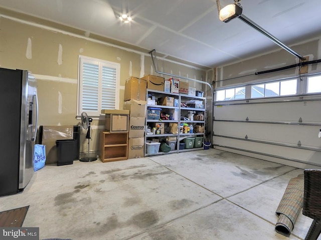 33016 Ethan Allen Dr, Rehoboth Beach, DE 19971 - garage with stainless steel refrigerator with ice dispenser and a garage door opener