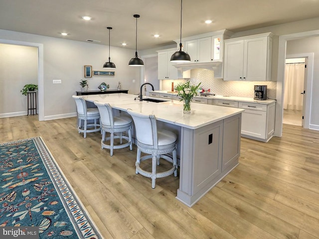 33016 Ethan Allen Dr, Rehoboth Beach, DE 19971 - kitchen with a sink, white cabinetry, light wood finished floors, and recessed lighting