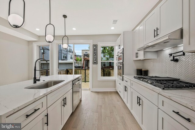 1713 4th St NW, Washington, DC 20001 - kitchen with a sink, under cabinet range hood, appliances with stainless steel finishes, tasteful backsplash, and white cabinets