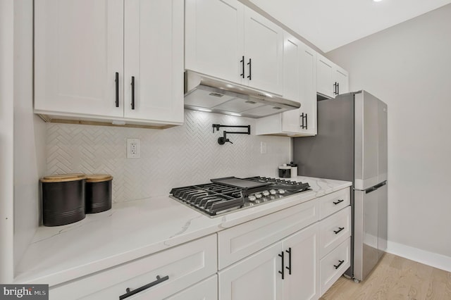 1713 4th St NW, Washington, DC 20001 - kitchen with under cabinet range hood, appliances with stainless steel finishes, tasteful backsplash, white cabinets, and light stone countertops
