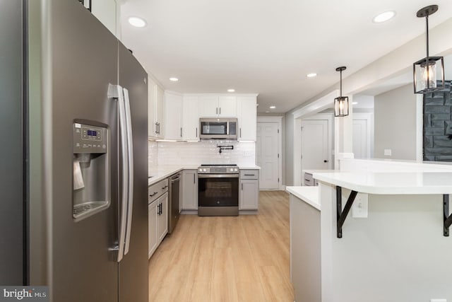 434 Bunker Hill Rd, Halifax, PA 17032 - kitchen with appliances with stainless steel finishes, light wood-style flooring, light countertops, decorative backsplash, and a kitchen breakfast bar