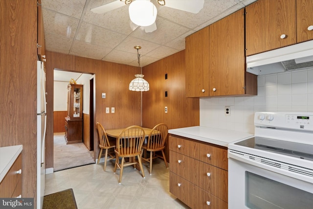 909 Rocklynn Rd, Springfield, PA 19064 - kitchen featuring white range with electric cooktop, brown cabinets, under cabinet range hood, light floors, and light countertops