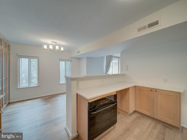 5017 7th Rd S Unit 101, Arlington, VA 22204 - kitchen with oven, light wood finished floors, light countertops, light brown cabinets, and a peninsula