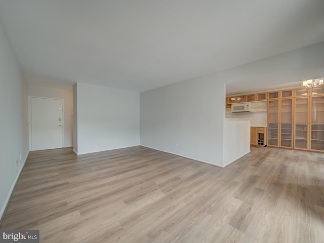 5017 7th Rd S Unit 101, Arlington, VA 22204 - unfurnished living room with light wood-style flooring, a chandelier, and baseboards