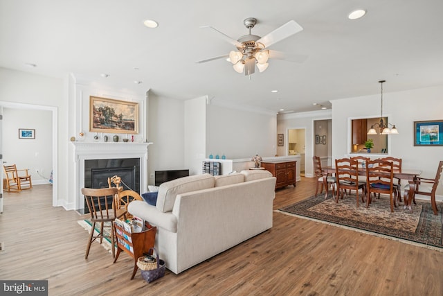 9 Brant Ct, Fredericksburg, VA 22406 - living room with light wood-type flooring, recessed lighting, a glass covered fireplace, crown molding, and a ceiling fan