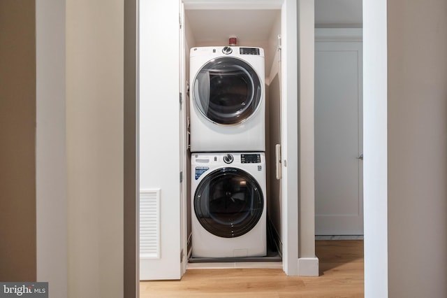 801 N Fairfax St Unit 314, Alexandria, VA 22314 - washroom with stacked washer / drying machine and light wood-style floors