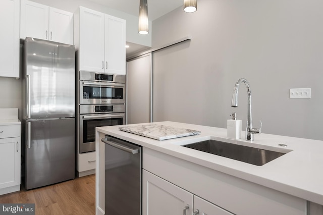 801 N Fairfax St Unit 314, Alexandria, VA 22314 - kitchen with appliances with stainless steel finishes, a sink, light countertops, and white cabinets