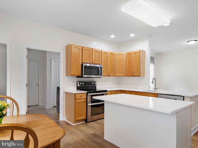 2 Assawoman Ave, Ocean View, DE 19970 - kitchen featuring stainless steel appliances, light wood finished floors, light countertops, a center island, and a peninsula