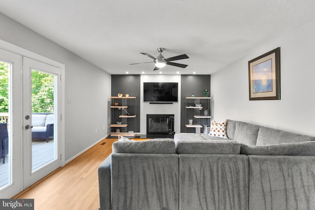 12407 Rousseau Ter, North Potomac, MD 20878 - living area featuring light wood-style flooring, ceiling fan, a large fireplace, and french doors