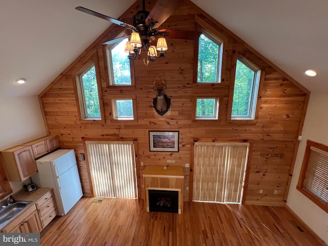1000 Cardinal View Rd, Paw Paw, WV 25434 - unfurnished living room with vaulted ceiling, wood walls, light wood finished floors, healthy amount of natural light, and a ceiling fan