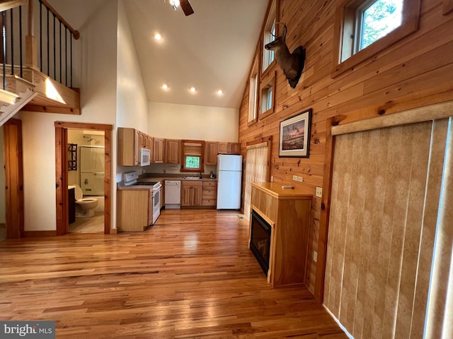 1000 Cardinal View Rd, Paw Paw, WV 25434 - kitchen with white appliances, high vaulted ceiling, light wood-style flooring, wooden walls, and a tile fireplace