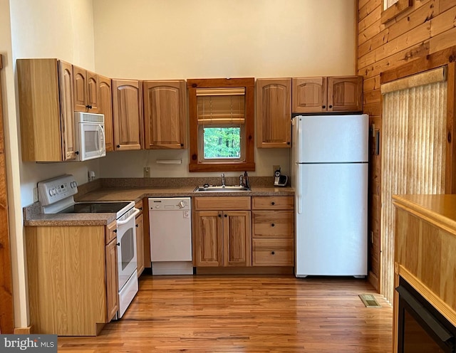 1000 Cardinal View Rd, Paw Paw, WV 25434 - kitchen with white appliances, a towering ceiling, light wood finished floors, brown cabinets, and wooden walls