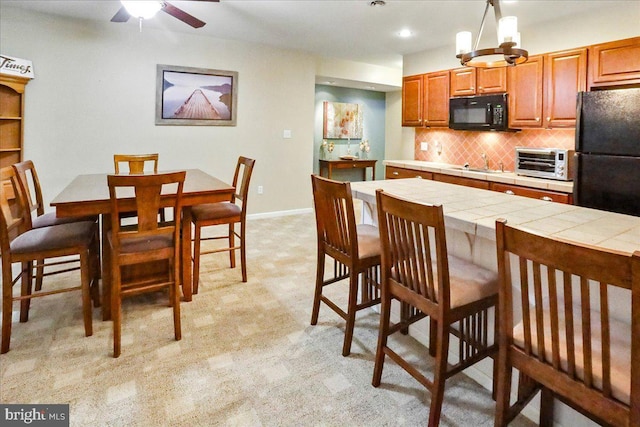 17 Shelly Dr, Reading, PA 19608 - kitchen featuring black appliances, tile countertops, decorative backsplash, a kitchen bar, and a ceiling fan