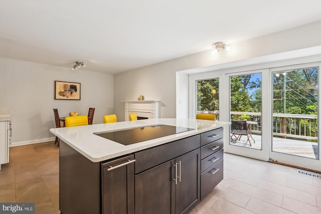 4410 S Pershing Ct, Arlington, VA 22204 - kitchen with black electric stovetop, light tile patterned floors, a kitchen island, and dark brown cabinetry