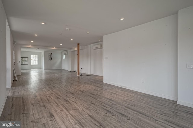 318 12th St, Hammonton, NJ 08037 - unfurnished living room with recessed lighting, wood finished floors, a wall unit AC, and baseboards