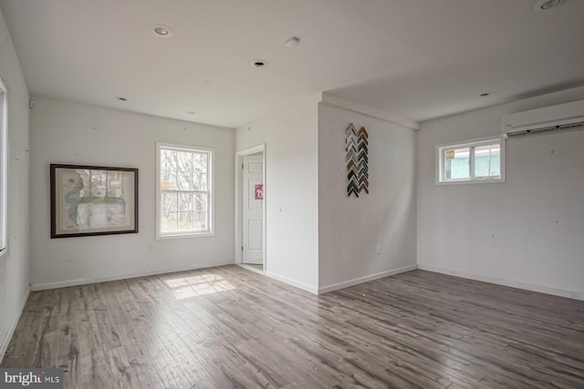 318 12th St, Hammonton, NJ 08037 - empty room with a wall unit AC, wood finished floors, and baseboards