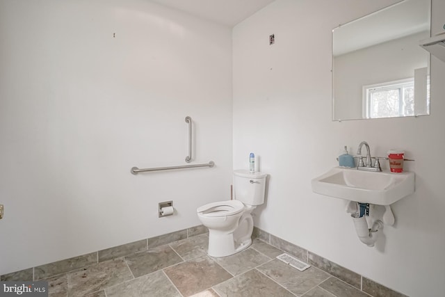 318 12th St, Hammonton, NJ 08037 - half bath featuring toilet, baseboards, a sink, and stone finish floors
