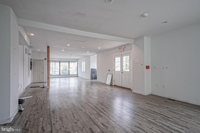 318 12th St, Hammonton, NJ 08037 - unfurnished living room featuring wood finished floors, recessed lighting, a wall mounted air conditioner, and baseboards