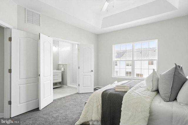 7710 Village Park Dr, Baltimore, MD 21222 - carpeted bedroom featuring a tray ceiling, connected bathroom, baseboards, and a ceiling fan