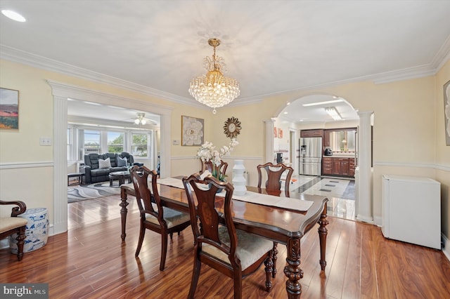 7200 Wayne Ave, Upper Darby, PA 19082 - dining room featuring arched walkways, light wood-style floors, ornamental molding, a chandelier, and decorative columns
