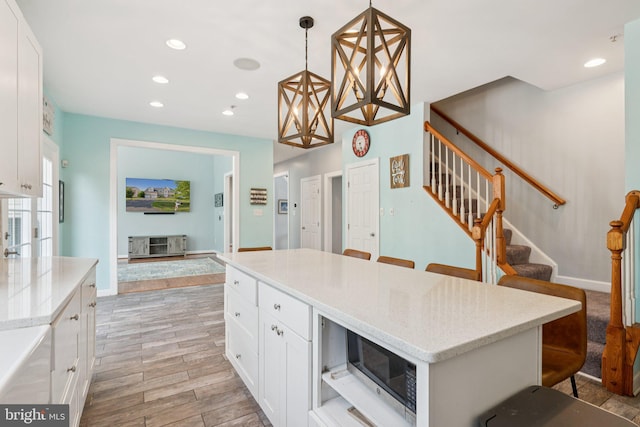 14520 Fairdale Rd, Silver Spring, MD 20905 - kitchen with a breakfast bar, recessed lighting, light wood-type flooring, white cabinetry, and baseboards