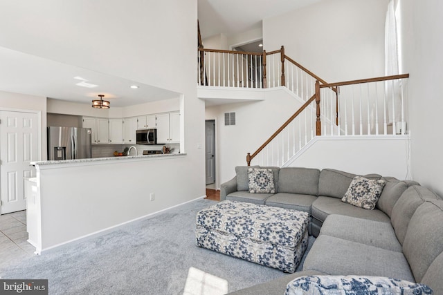 1112 Cornwallis Way, Collegeville, PA 19426 - living area with stairs, light colored carpet, a high ceiling, and baseboards