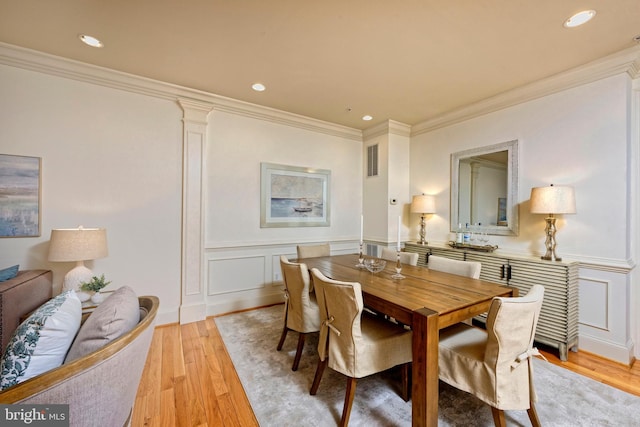 404 Oronoco St, Alexandria, VA 22314 - dining room featuring ornamental molding, light wood-style floors, recessed lighting, a decorative wall, and a wainscoted wall