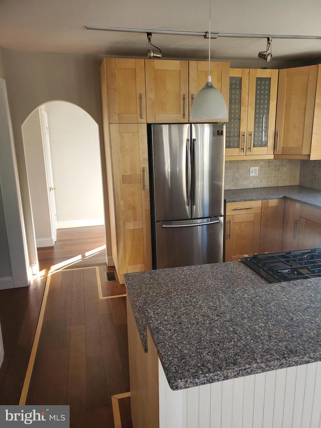 3004 Dekalb Pike, East Norriton, PA 19401 - kitchen featuring freestanding refrigerator, dark wood-style flooring, arched walkways, glass insert cabinets, and decorative backsplash