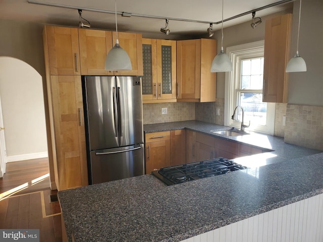 3004 Dekalb Pike, East Norriton, PA 19401 - kitchen with freestanding refrigerator, a sink, glass insert cabinets, tasteful backsplash, and arched walkways