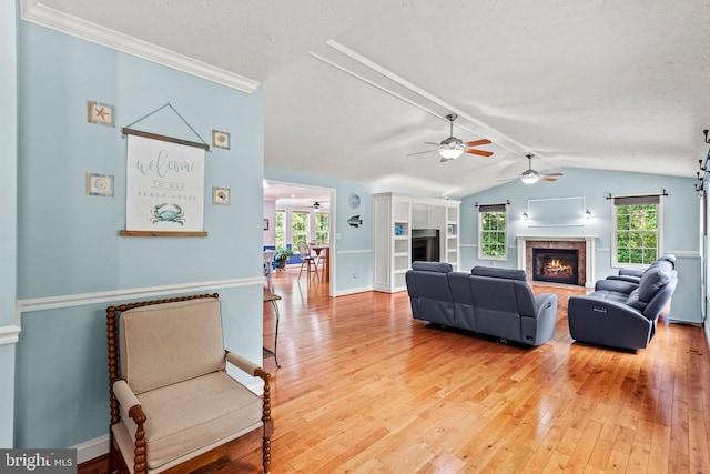 26471 N Sandgates Rd, Mechanicsville, MD 20659 - living room featuring a warm lit fireplace, a ceiling fan, light wood-style flooring, vaulted ceiling, and baseboards