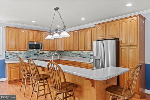 26471 N Sandgates Rd, Mechanicsville, MD 20659 - kitchen with stainless steel appliances, light countertops, ornamental molding, light wood-style flooring, and decorative backsplash