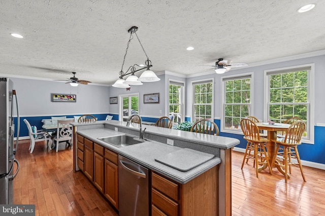 26471 N Sandgates Rd, Mechanicsville, MD 20659 - kitchen featuring stainless steel appliances, a sink, ceiling fan, crown molding, and brown cabinetry