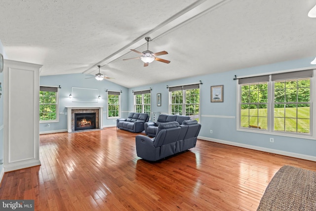 26471 N Sandgates Rd, Mechanicsville, MD 20659 - living room featuring wood-type flooring, a fireplace with flush hearth, healthy amount of natural light, baseboards, and a textured ceiling