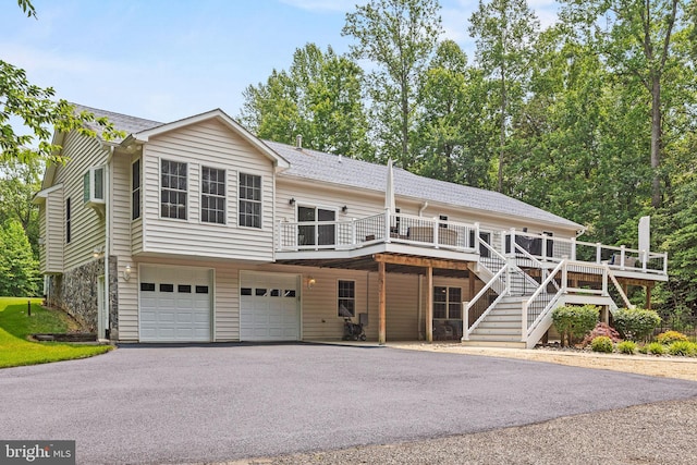 26471 N Sandgates Rd, Mechanicsville, MD 20659 - view of front of home featuring asphalt driveway, an attached garage, a wooden deck, stairway, and a shingled roof