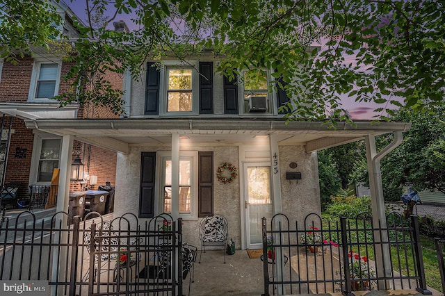 453 Old Elm St, Conshohocken, PA 19428 - view of front facade with covered porch, a gate, a fenced front yard, and stucco siding