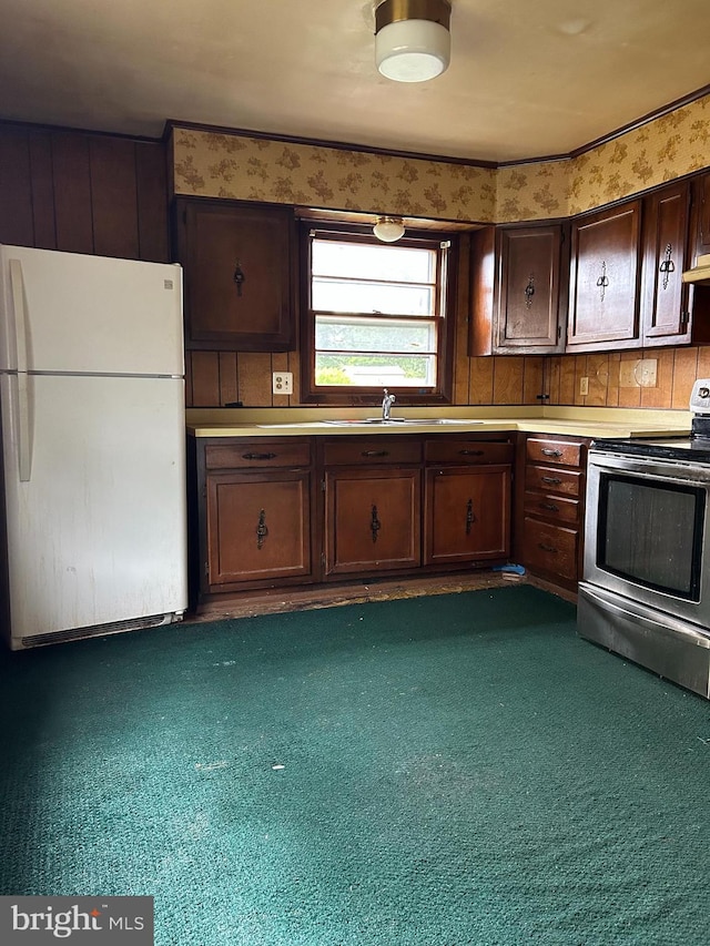 7303 Leona St, District Heights, MD 20747 - kitchen featuring freestanding refrigerator, stainless steel range with electric cooktop, dark brown cabinetry, light countertops, and a sink