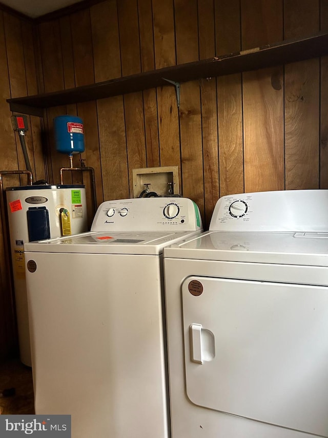 7303 Leona St, District Heights, MD 20747 - laundry area featuring water heater, washer and clothes dryer, and wood walls