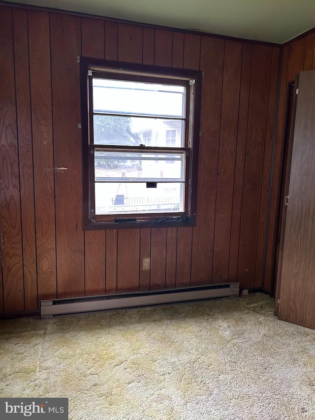 7303 Leona St, District Heights, MD 20747 - carpeted empty room featuring baseboard heating, healthy amount of natural light, and wooden walls