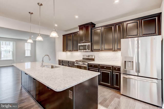 9608 Julia Ln, Owings Mills, MD 21117 - kitchen with appliances with stainless steel finishes, a sink, light wood-type flooring, light stone countertops, and tasteful backsplash