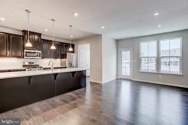 9608 Julia Ln, Owings Mills, MD 21117 - kitchen with appliances with stainless steel finishes, a breakfast bar, backsplash, light stone countertops, and recessed lighting