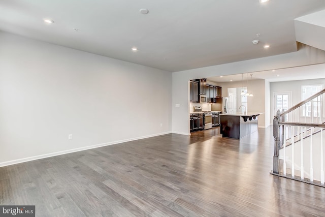 9608 Julia Ln, Owings Mills, MD 21117 - unfurnished living room featuring dark wood-type flooring, baseboards, stairway, recessed lighting, and a sink