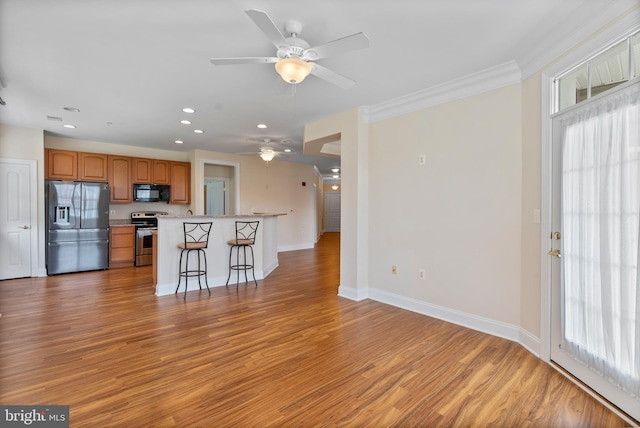 902 Macphail Woods Xing Unit 2I, Bel Air, MD 21015 - kitchen featuring appliances with stainless steel finishes, ceiling fan, a kitchen breakfast bar, light countertops, and light wood-type flooring